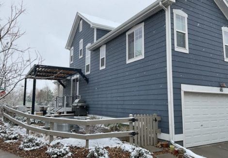 snow covered house with blue-grey trim