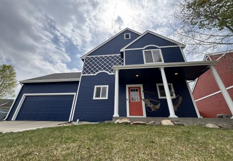 blue painted house with white trim and red door