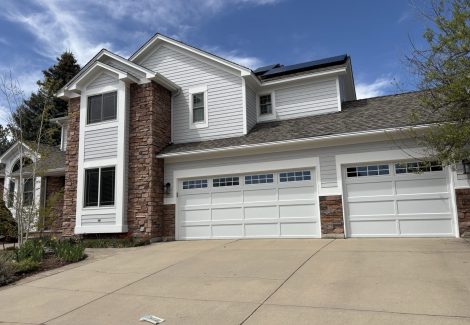front exterior of house with stone and painted siding | garage view