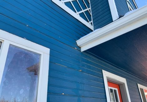 blue house with damaged paint