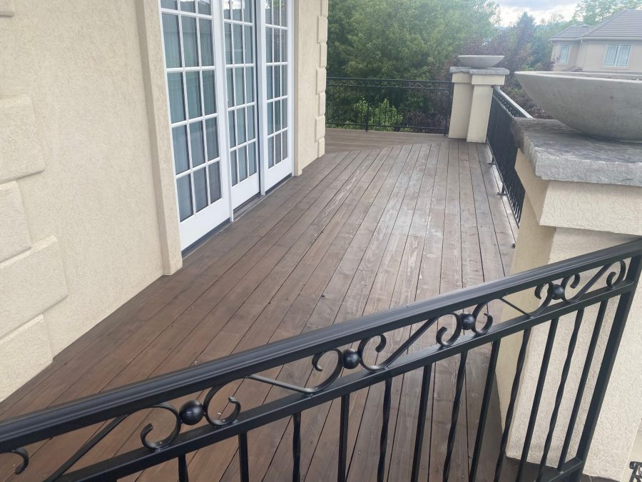 stained wooden deck against house with black metal railing Preview Image 8
