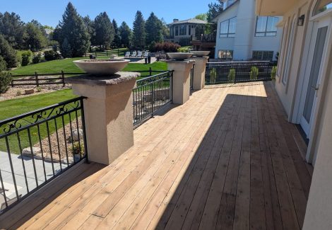 stripped wooden deck with metal railing
