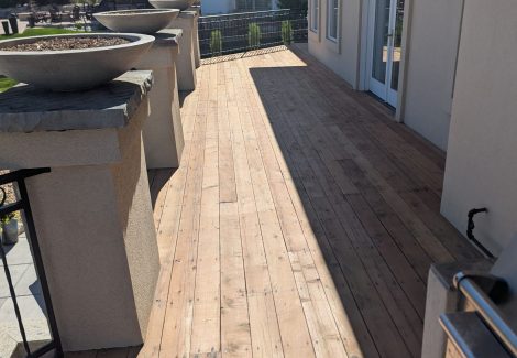 stripped wooden deck with metal railing