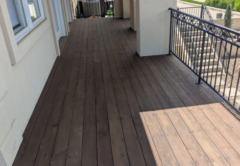 stripped wooden deck with metal railing