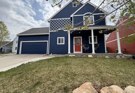 blue painted house with white trim and red door
