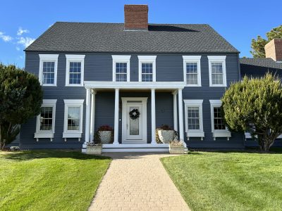 front view of house with grey painted siding and white trim