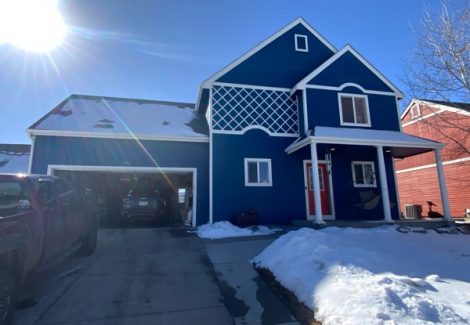 blue painted house with white trim and red door