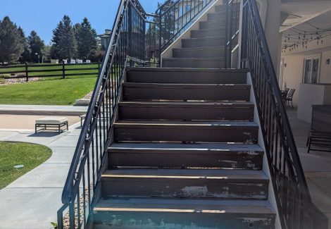 wooden deck staircase with black metal railing