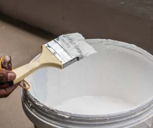 white paint bucket with a paintbrush