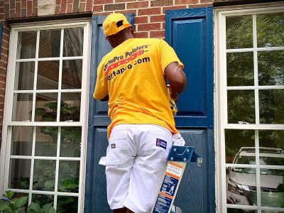 Man in Gold Shirt Painting Shutters