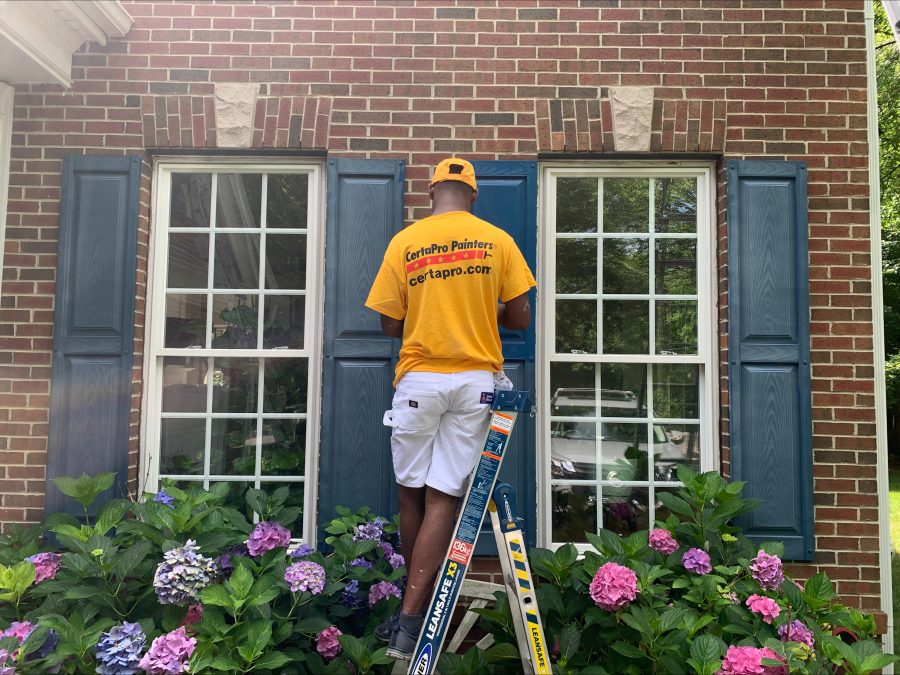 Man in Yellow Shirt Painting Shutters Preview Image 4
