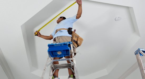 Man measuring a curved crown molding section