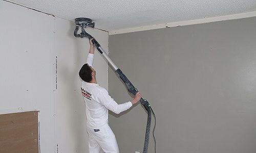 worker removing popcorn ceiling
