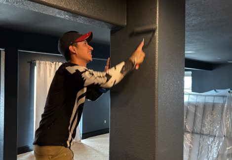 painter using roller to paint wall column