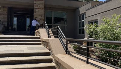 stone paved entrance and steps with painted metal railing