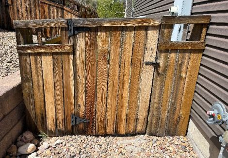 wooden fence outside of a home with worn stain
