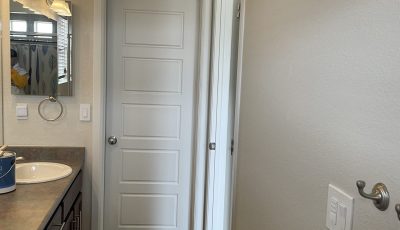 home bathroom with double sink and white painted doors
