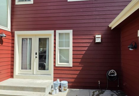 house exterior with dark red painted siding and white trim