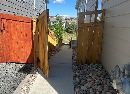 unstained fence gate against house