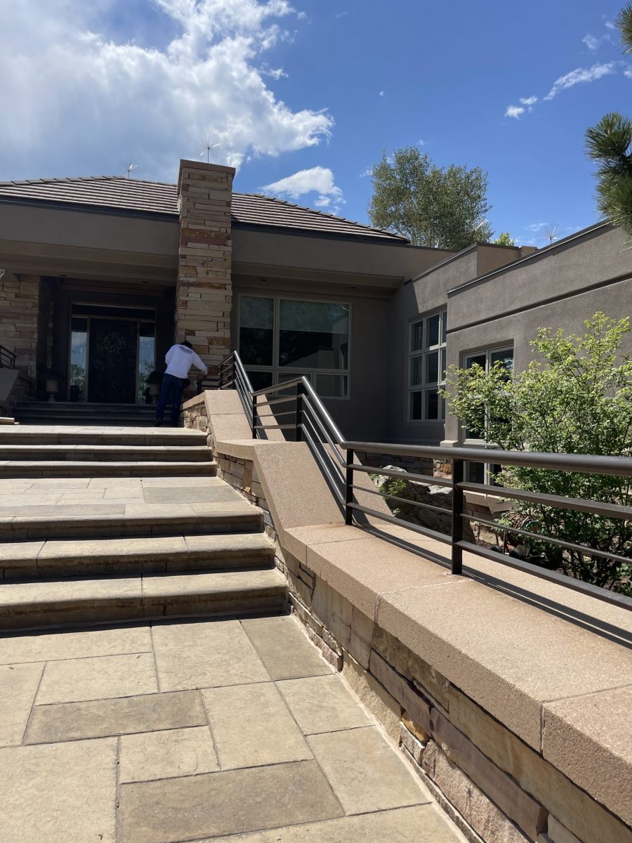stone paved entrance and steps with painted metal railing
