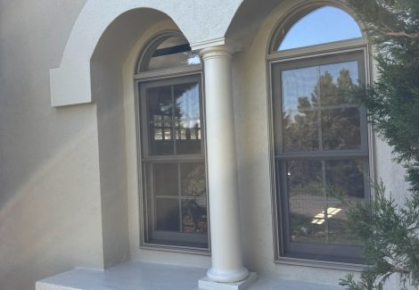 windows on side of painted stucco house