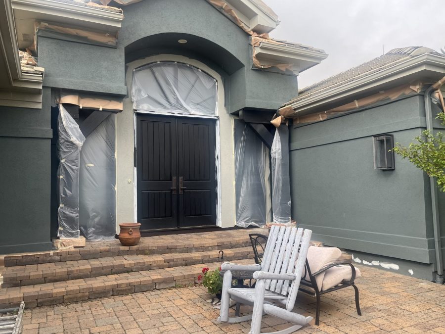 side of blue painted stucco house with protective covering on trim Preview Image 3