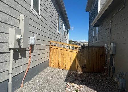 unstained fence gate between houses
