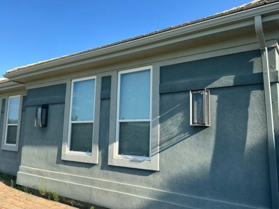 side of blue painted stucco house Preview Image 2