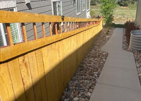 unstained fence surrounding house and yard