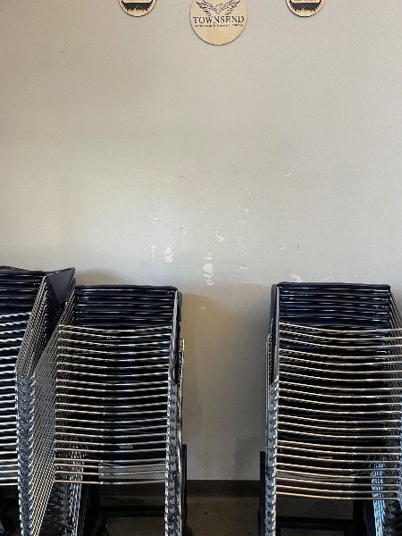 stacked chairs against wall with chipped paint Preview Image 7