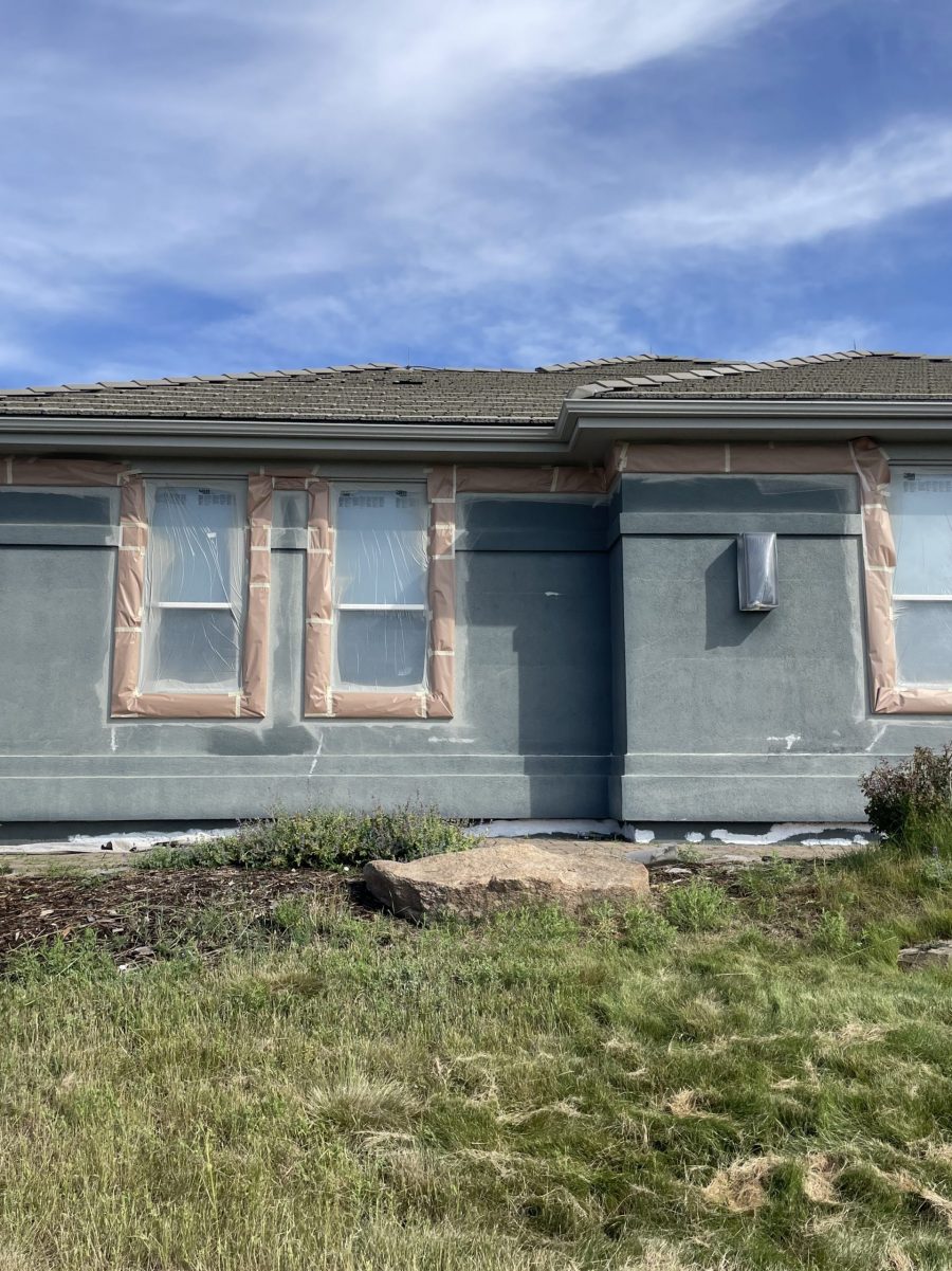 side of blue painted stucco house with protective covering on trim Preview Image 5