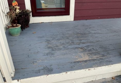 wooden porch with worrn grey paint and white trim