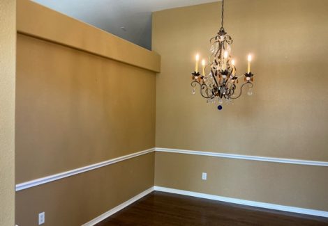empty home interior room with chandelier and chair rail