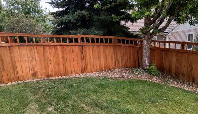 stained fence surrounding home and yard