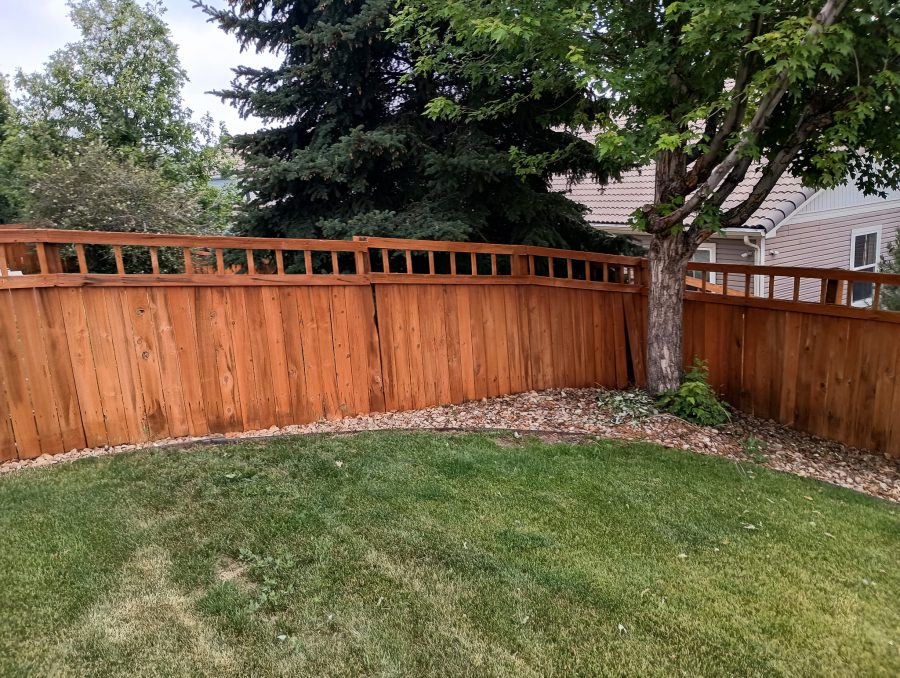 stained fence surrounding home and yard