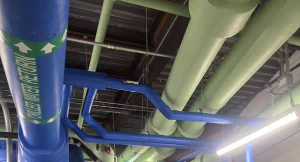 boiler room with orange, blue and green painted pipes