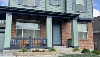 painted house exterior with light seafoam green siding and navy trim