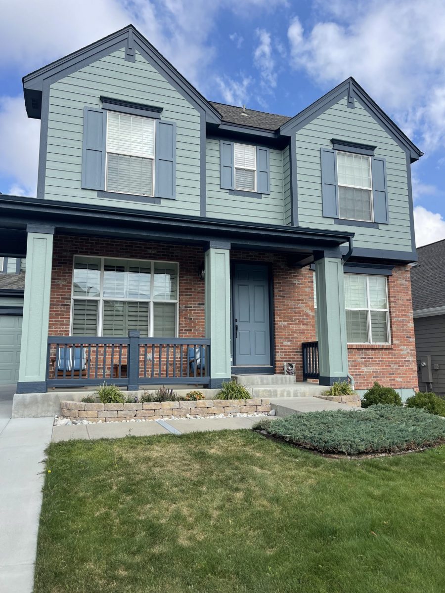 painted house exterior with light seafoam green siding and navy trim