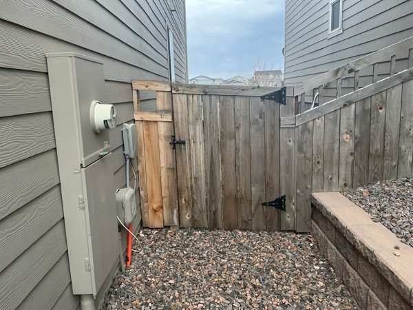worn wooden fence gate against house Preview Image 5