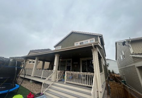 house exterior with faded green siding and beige porch