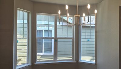 painted room with large windows and chandelier