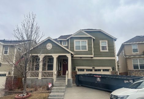 house exterior with faded green siding and beige accents