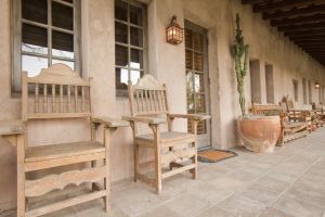 Old wooden chairs on a ranch house covered porch.