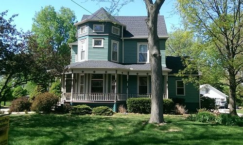 Victorian Style Home with Green Siding and White Window Trim
