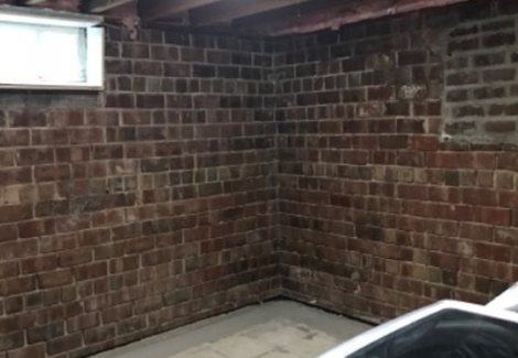 washer and dryer in brick-walled room