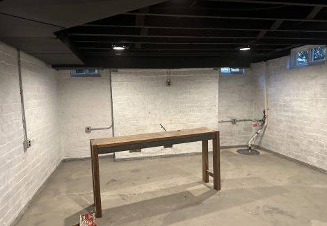 basement room with whitewashed brick wall and table