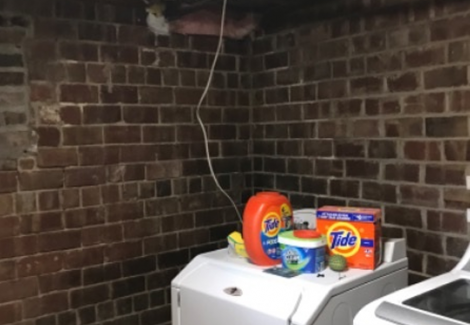 washer and dryer in brick-walled room