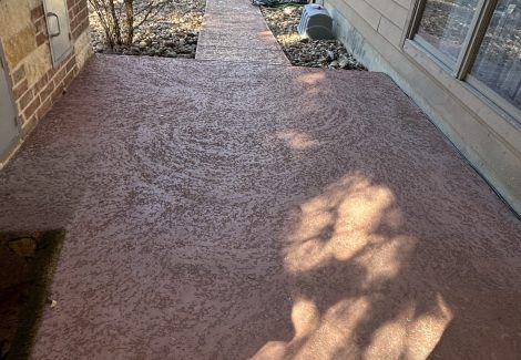 concrete walkway with worn red paint