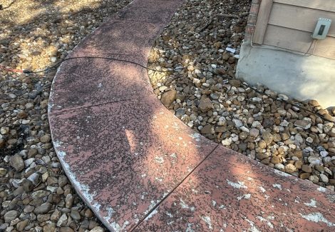 concrete walkway with worn red paint