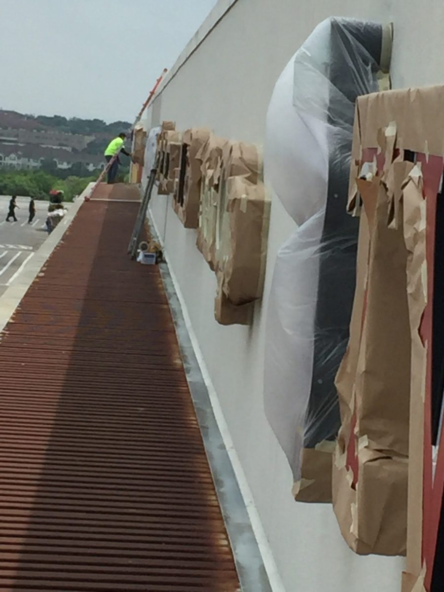 storefront sign wrapped in covering as painter paints exterior wall around it Preview Image 12